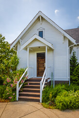 Obraz premium Entrance to a home through a beautiful garden with green lawn and flowers. House with garden design