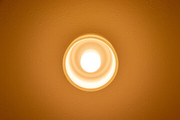 天井から部屋を照らすオレンジ色の照明器具