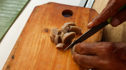 Fototapeta na wymiar Hands cutting meatballs on a cutting board for cooking ingredients