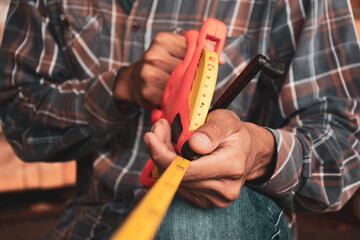 Closeup of a hand holding a tape measure in civil construction.