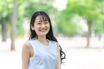 新緑の中にいる笑顔の日本人女性
