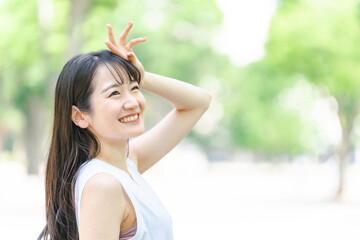 新緑の中で日光を浴びる日本人女性（紫外線対策・日焼け止め）
 - obrazy, fototapety, plakaty