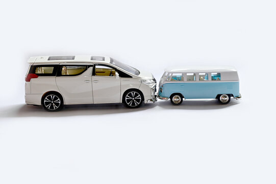 BANGKOK, THAILAND - July 17, 2022 : New Toy Cars Model White Pearl Crystal Toyota Alphard Minivan and Blue-Green VW Volkswagon Camper van turn the car heads together isolated on white background.