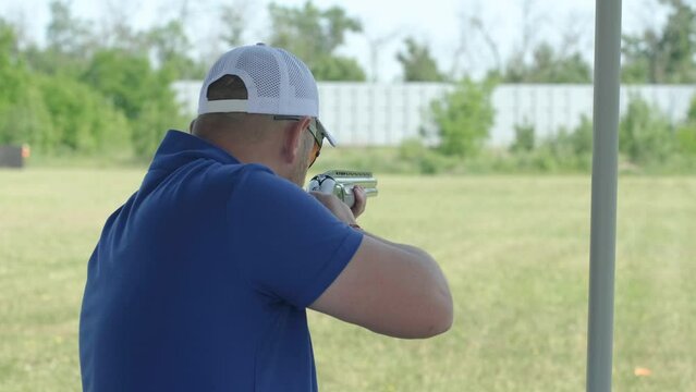 Sportsman shoots from a double-barreled shotgun, A sports field for a shooting test is shooting at flying skeet
