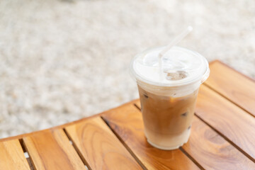 Selective focus, Fresh coffee, iced cappuccino, Macchiato, latte with separate milk and coffee. Coffee in a plastic cup on a wooden table. plastic iced coffee mug on wooden table