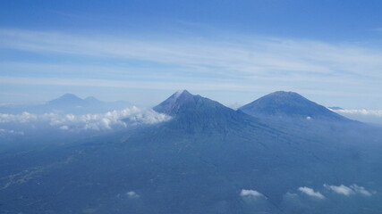 Fototapeta na wymiar an aerial view of two mountains in Yogyakarta and Central Java, Indonesia. The left mountain is Mount Merapi, the most active volcano in Indonesia and the right one is Mount Merbabu