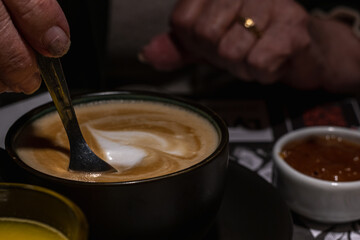 sweetening with sugar that falls the coffee with milk