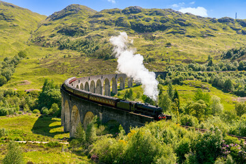 Glenfinnan Railway Viaduct in Scotland with the steam train passing over