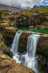 Fototapeta na wymiar Cascading waterfalls and green water of the Fairy Pools in Isle of Skye 