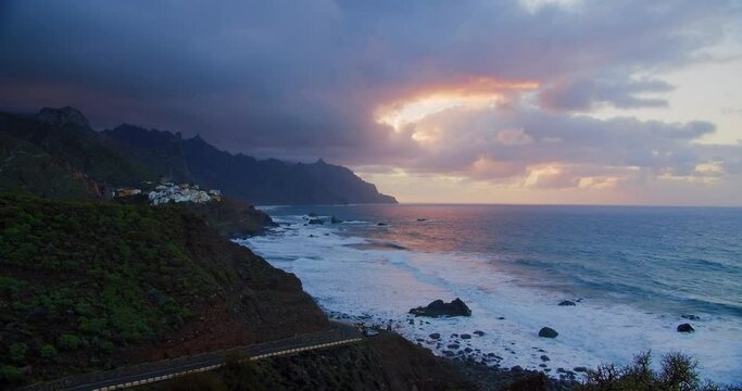 Amazing view of Almaciga village on cliff rocks and turquoise ocean at sunset. Tenerife, Anaga, Canary islands, Europe. Travel destination, adventure concept. Slow motion.