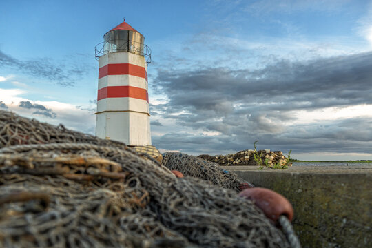 Fischernetz vor einem Leuchtturm