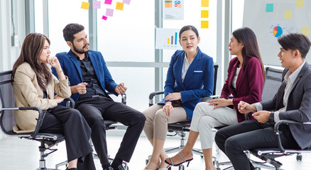 Millennial Indian Asian professional successful male female businessman businesswoman group in formal suit sitting together discussing brainstorming sharing business solution ideas in meeting room