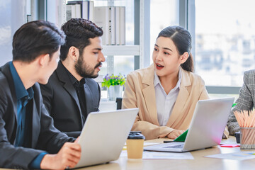 Group of millennial Asian Indian multinational multicultural male and female businessman businesswoman teamwork in formal suit sitting smiling brainstorming meeting together in office conference room