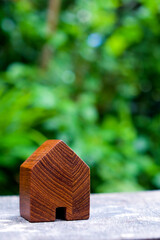 wood house model on wood table with green nature background , eco house icon concept.