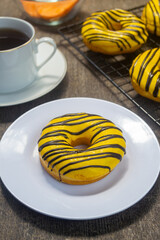 Donat ubi kuning or yellow sweet potato donuts. made from yellow sweet potato with banana flavored chocolate on top. has a soft texture