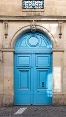 Fototapeta na wymiar Paris, an old wooden door, with a head carved on the lintel, typical building in the Marais 