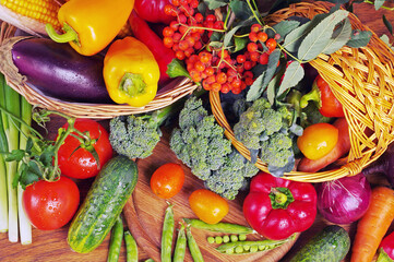 A variety of colored fresh vegetables on a wooden table.