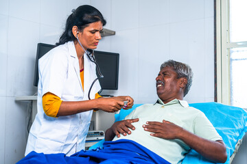 Doctor checking suffering senior man chest pain at hospital ward - concept of health care treatment , cardiac arrest and professional occupation