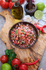 freshly made salsa dip sauce - chopped garlic, tomatoes and onion in wooden bowl