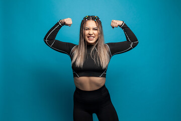 Young fitness woman doing sport on blue background