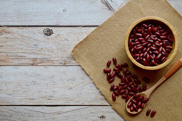 Top Views of Dried Kidney Beans in a wooden cup Some are in wooden spoons and sackcloth on the wooden background, Healthy Food Concept.
