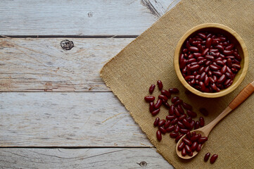 Top Views of Dried Kidney Beans in a wooden cup Some are in wooden spoons and sackcloth on the wooden background, Healthy Food Concept.