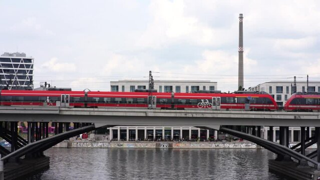 A red train drives over a bridge in Berlin.