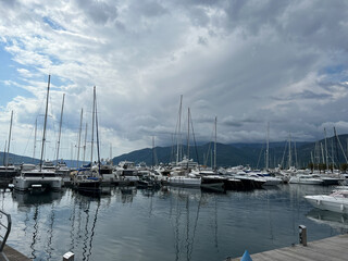 Fototapeta na wymiar Sailing yachts stand at the pier against the backdrop of the mountains