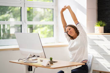 Woman Stretches At Office Desk