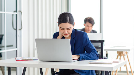 Obraz premium Asian stressed exhausted tired female businesswoman secretary working late and hard sitting at workplace in company take off glasses hold hand massaging painful shoulder from office syndrome symptom