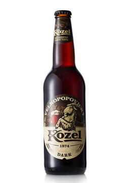 LONDON,UK - JUNE 30, 2022: Kozel dark beer in glass bottle on white background. Authentic czech taste.
