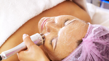 Woman in a spa salon on cosmetic procedures for facial care. Beautician makes medical procedures...