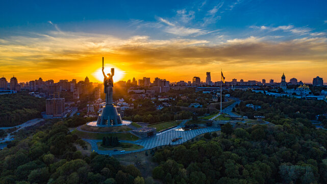 Aerial view to the Motherland statue in the Kiev while  summer sunset. The well-known landmarks in Kyiv. Historical monument of Soviet union. Beautiful city Kiev while sunset.