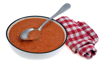 Assiette de gaspacho maison avec une cuillère et une serviette de table sur fond blanc