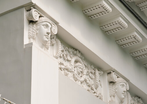part of an old manison facade decorated with stone faces and stucco. historical building or palace. ancient culture heritage.