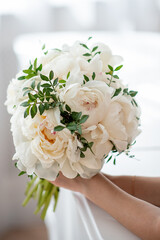 wedding bouquet of white peonies in the hands of the bride. concept for event agencies and floristry