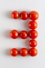 Obraz premium Number three. A figure of cherry tomatoes on a white background. Tomatoes close-up. Tomatoes in the form of the Number three