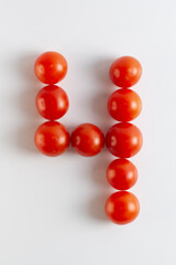 Number four. A figure of cherry tomatoes on a white background. Tomatoes close-up. Tomatoes in the form of the Number four
