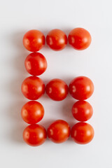 Number six. A figure of cherry tomatoes on a white background. Tomatoes close-up. Tomatoes in the form of the Number six