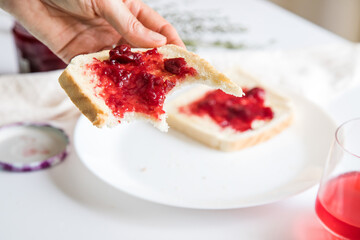 Break to eat. Pleasant and tasty moment of relaxation and tasting. Table with a glass of strawberry gelatin and toast with red fruit jam. 