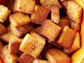 Salted croutons in a bowl on a yellow background