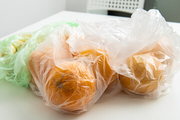 Fresh ripe fruits in transparent bags on a white background