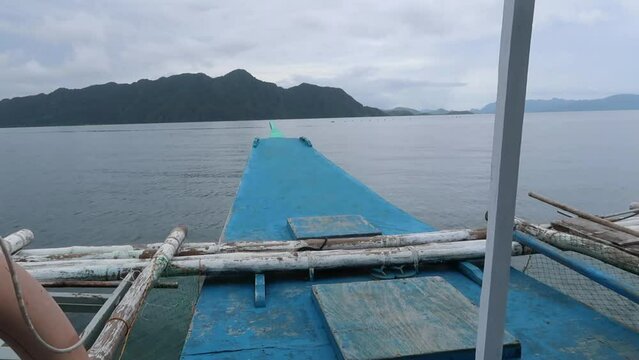 Outrigger bangka boat moving across the pristine water at Palawan, an archipelagic province of the Philippines that is located in the region of Mimaropa.