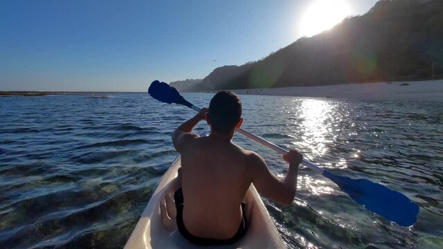 Indonesian Man Canoeing Canoe at Gunung Payung Beach, Bali, Indonesia