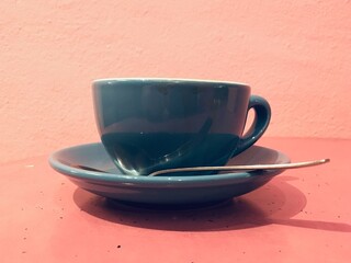cup of coffee against pink wall