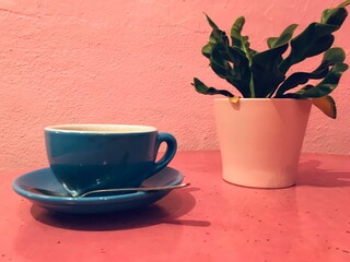 cup of coffee against pink wall