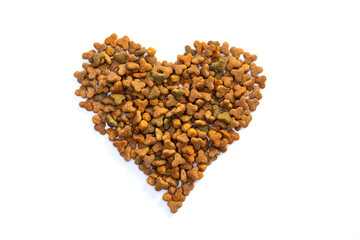 Dry food for cats or dogs in the shape of a heart on a white background. The concept of love and care for pets