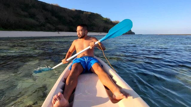 Indonesian Man Canoeing Canoe at Gunung Payung Beach, Bali, Indonesia