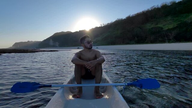Indonesian Man Canoeing Canoe at Gunung Payung Beach, Bali, Indonesia