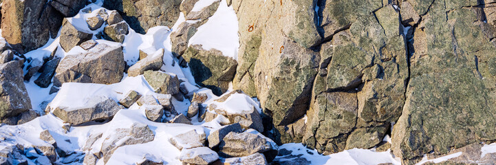 Rocks covered in snow. Wide panoramic background for design.